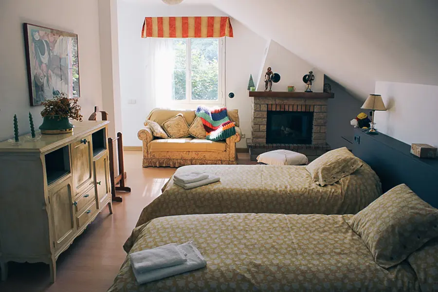 Salón abuhardillado de Casa Larrate con chimenea