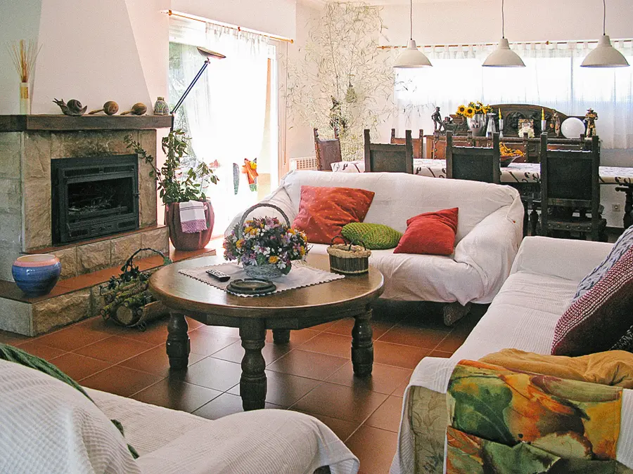 Salón principal de Casa Larrate con chimenea y zona de comedor